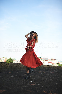 Buy stock photo Shot of a beautiful young woman posing on the rooftop of a building