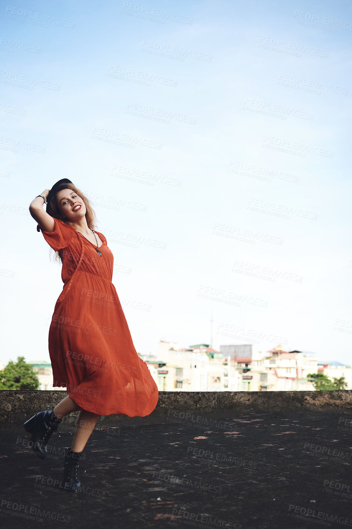 Buy stock photo Shot of a beautiful young woman posing on the rooftop of a building