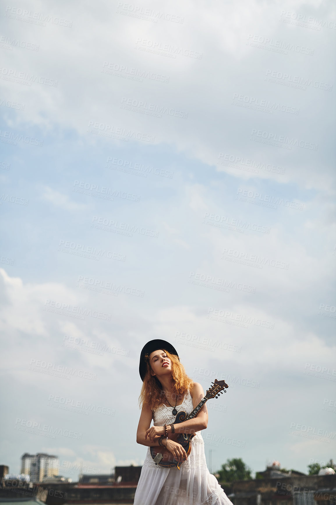 Buy stock photo Woman, roof and guitar in city for music with reflection, inspiration and mock up space with clouds in sky. Girl, person and artist with hug for instrument, talent and ready for concert in Ireland