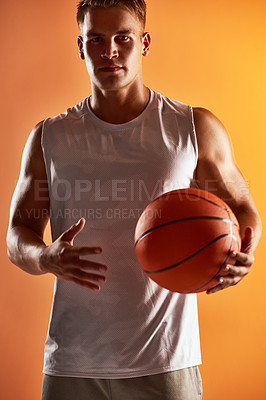 Buy stock photo Studio portrait of a handsome young male basketball player posing against an orange background