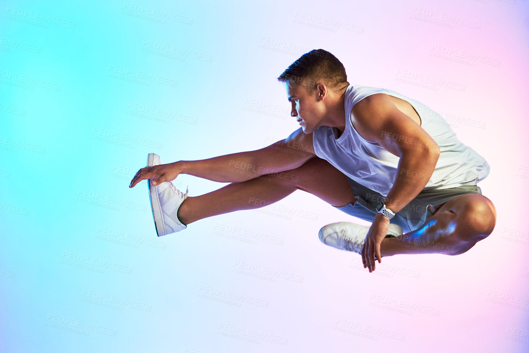 Buy stock photo Studio shot of a handsome young male athlete jumping against a multi-coloured background