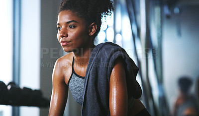 Buy stock photo Shot of a sporty young woman taking a break while exercising at the gym