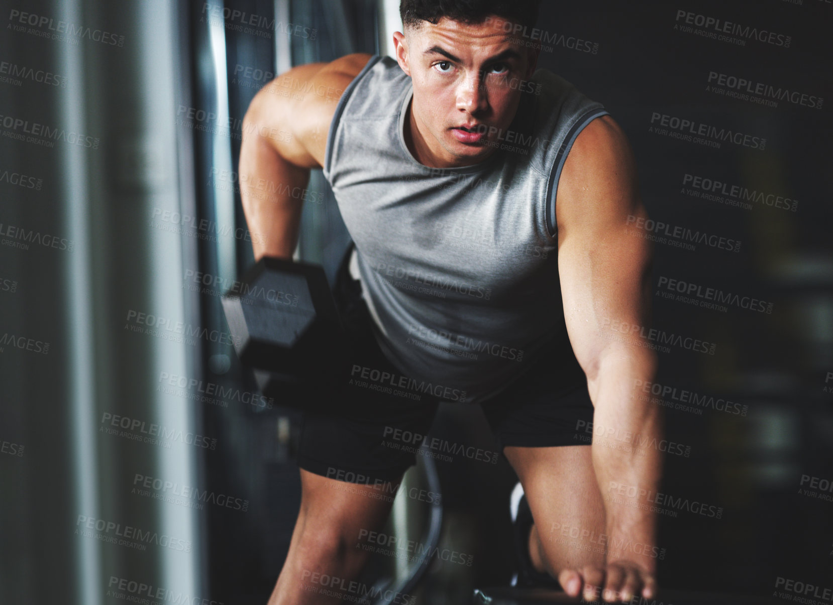 Buy stock photo Portrait of a sporty young man exercising with a dumbbell at the gym