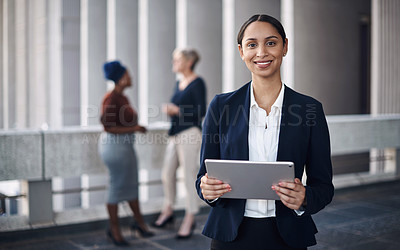 Buy stock photo Shot of a young businesswoman using a digital tablet against a city background