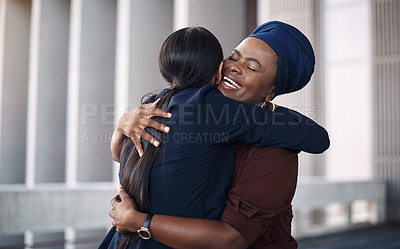 Buy stock photo Shot of two young businesswomen hugging against a city background