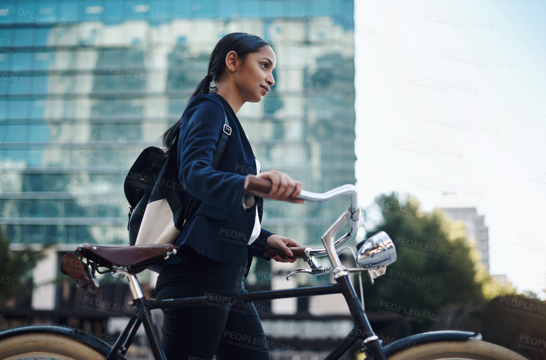 Buy stock photo Shot of a young businesswoman traveling with a bicycle through the city