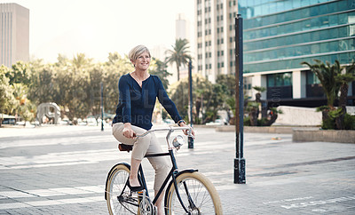 Buy stock photo Shot of a mature businesswoman traveling with a bicycle through the city