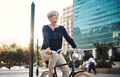 Buy stock photo Shot of a mature businesswoman traveling with a bicycle through the city