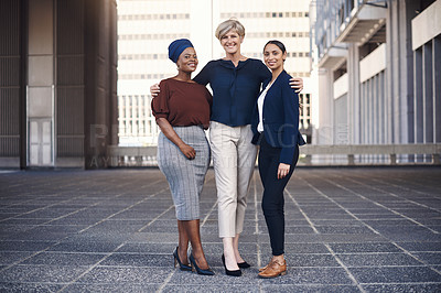 Buy stock photo Portrait of a group of businesswomen standing together against a city background