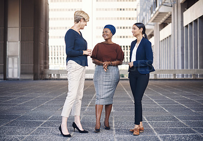 Buy stock photo Shot of a group of businesswomen having a discussion against a city background