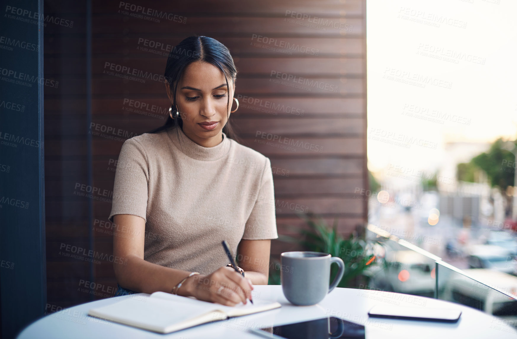 Buy stock photo Cropped shot of an attractive young businesswoman taking notes while working in her office