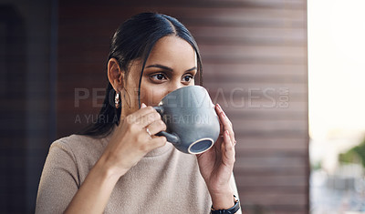 Buy stock photo Cropped shot of an attractive young businesswoman drinking her coffee while working in the office