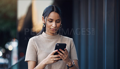 Buy stock photo Cropped shot of an attractive young businesswoman sending a text while working in her office