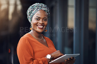 Buy stock photo Cropped portrait of an attractive businesswoman using her tablet while standing in the office