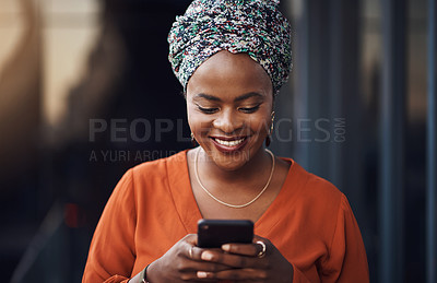 Buy stock photo Cropped shot of an attractive businesswoman sending a text while standing in the office