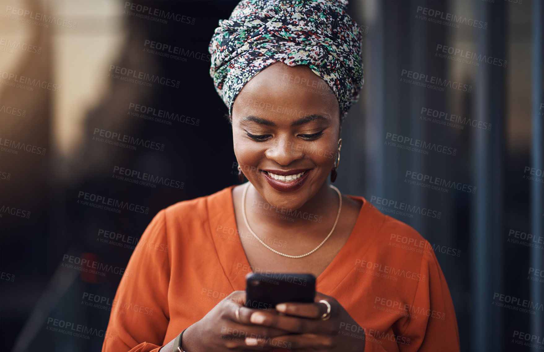 Buy stock photo Cropped shot of an attractive businesswoman sending a text while standing in the office
