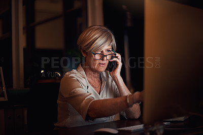Buy stock photo Cropped shot of an attractive mature businesswoman working on her computer and making a phonecall in the office late at night