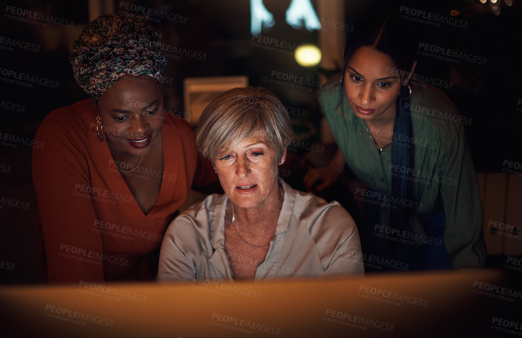 Buy stock photo Shot of a group of businesswomen working together on a computer in an office at night