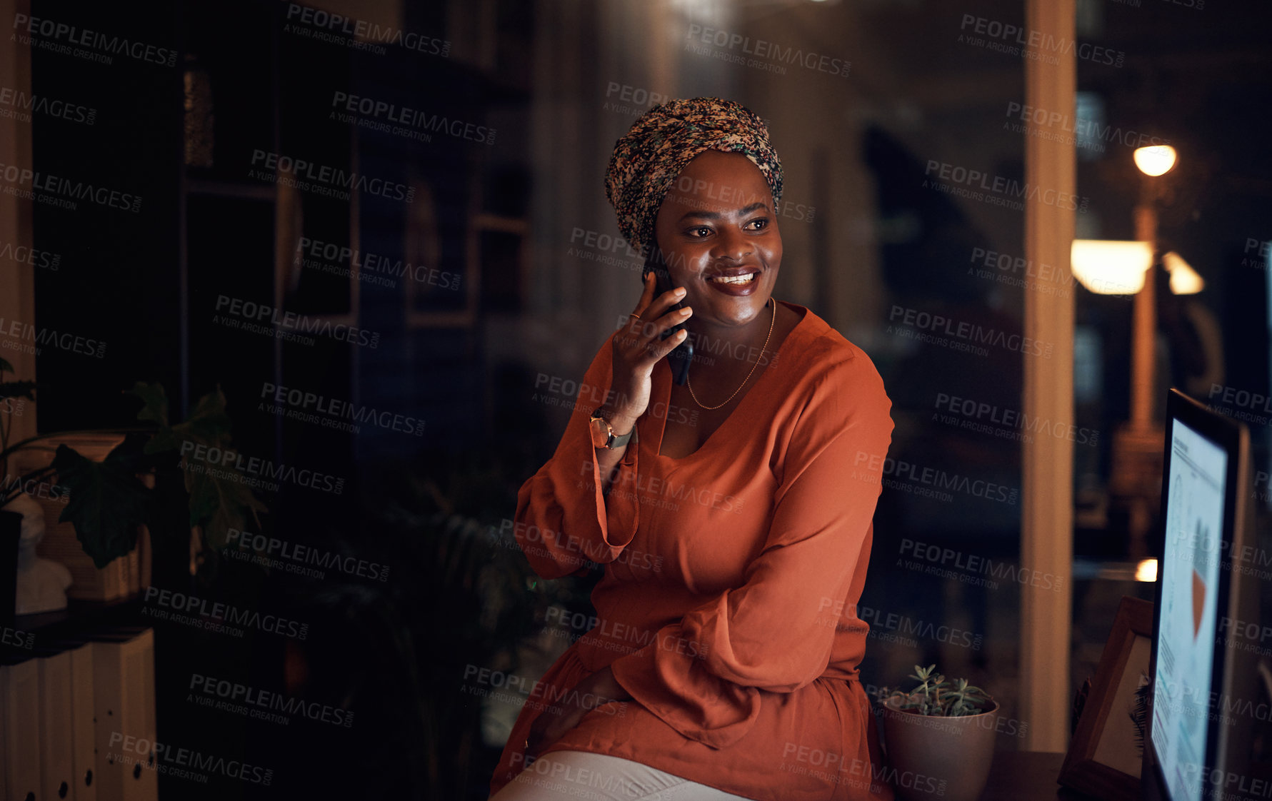 Buy stock photo Shot of a young businesswoman talking on a cellphone in an office at night