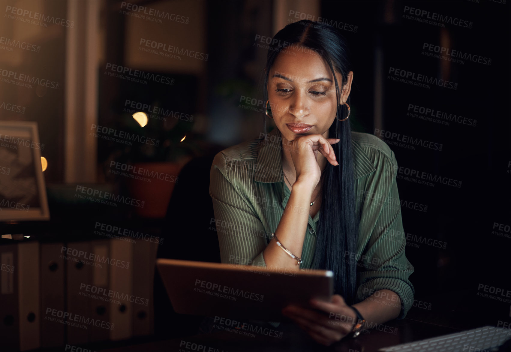 Buy stock photo Shot of a young businesswoman using a digital tablet in an office at night