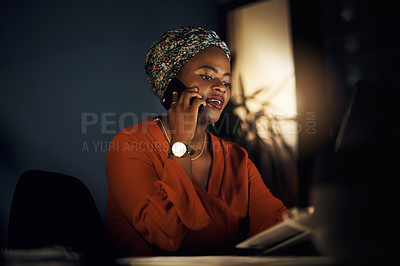Buy stock photo Shot of a young businesswoman talking on a cellphone while using a laptop in an office at night