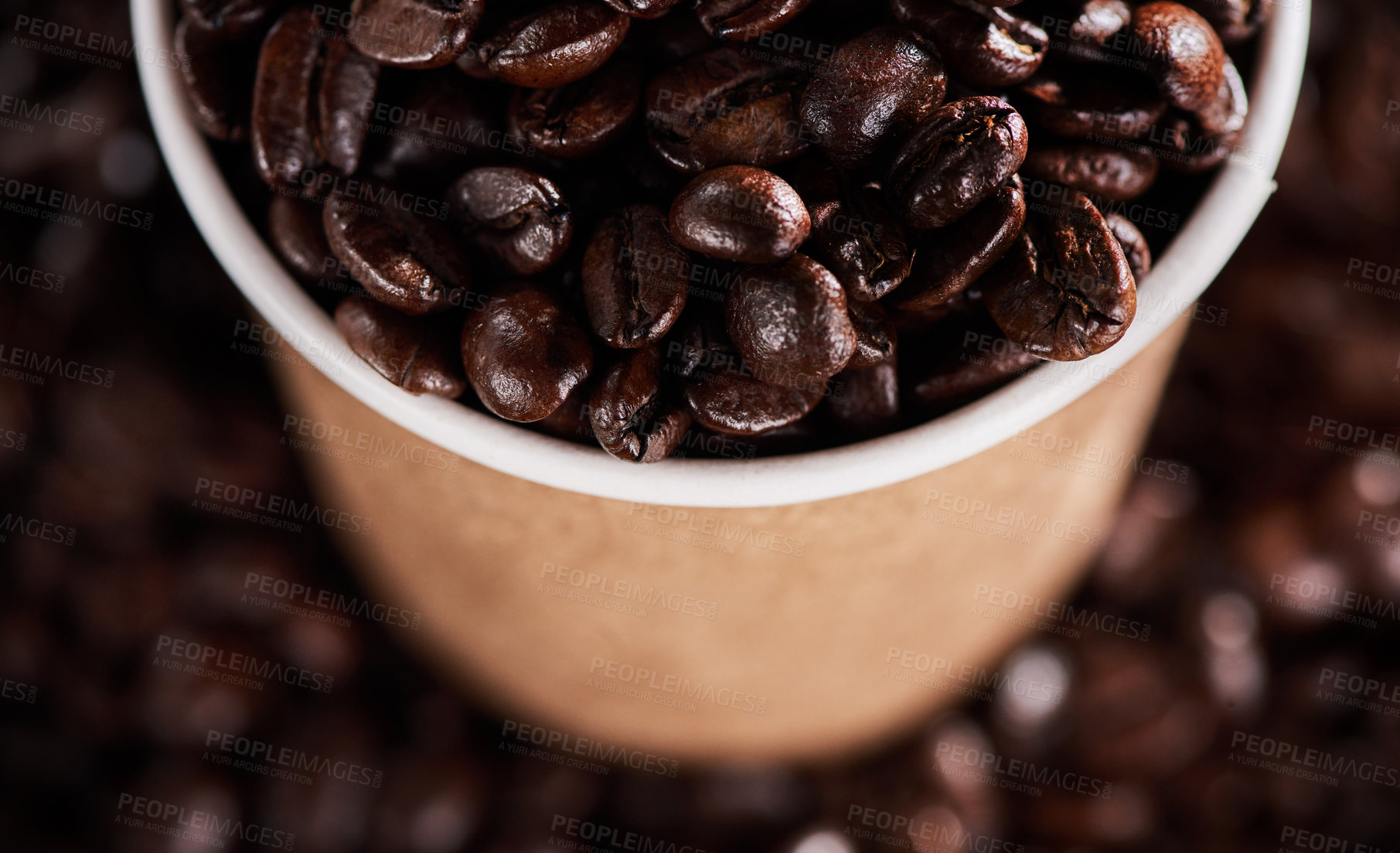 Buy stock photo Closeup shot of a paper cup filled with coffee beans