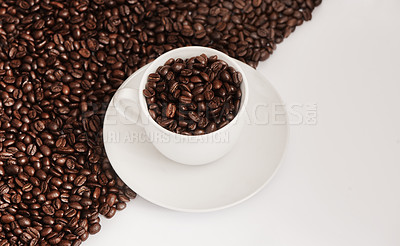 Buy stock photo Closeup shot of a cup filled with coffee beans against a half-and-half background