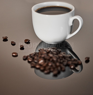 Buy stock photo Closeup shot of a cup of black coffee and coffee beans on a reflective surface