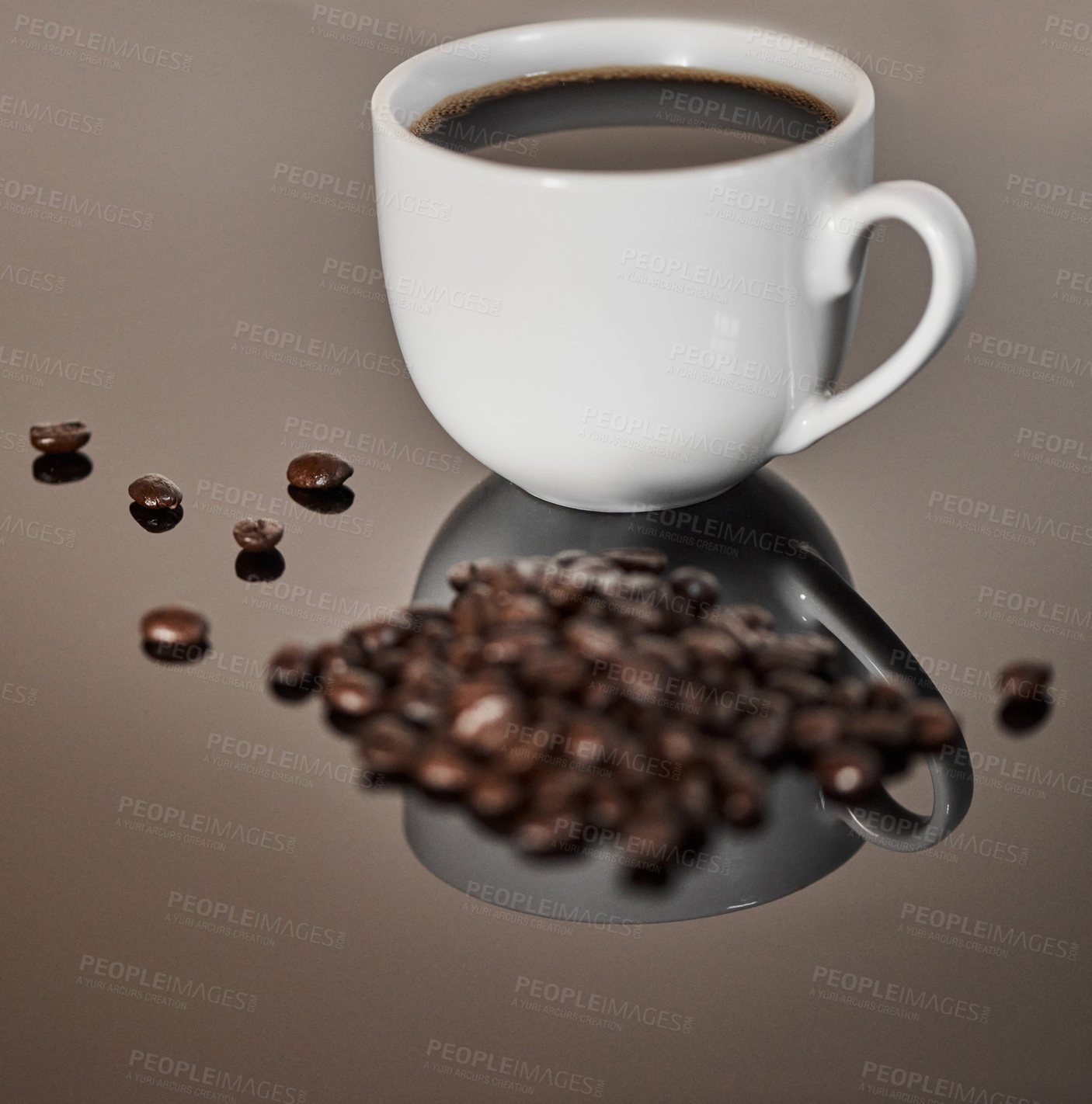 Buy stock photo Closeup shot of a cup of black coffee and coffee beans on a reflective surface