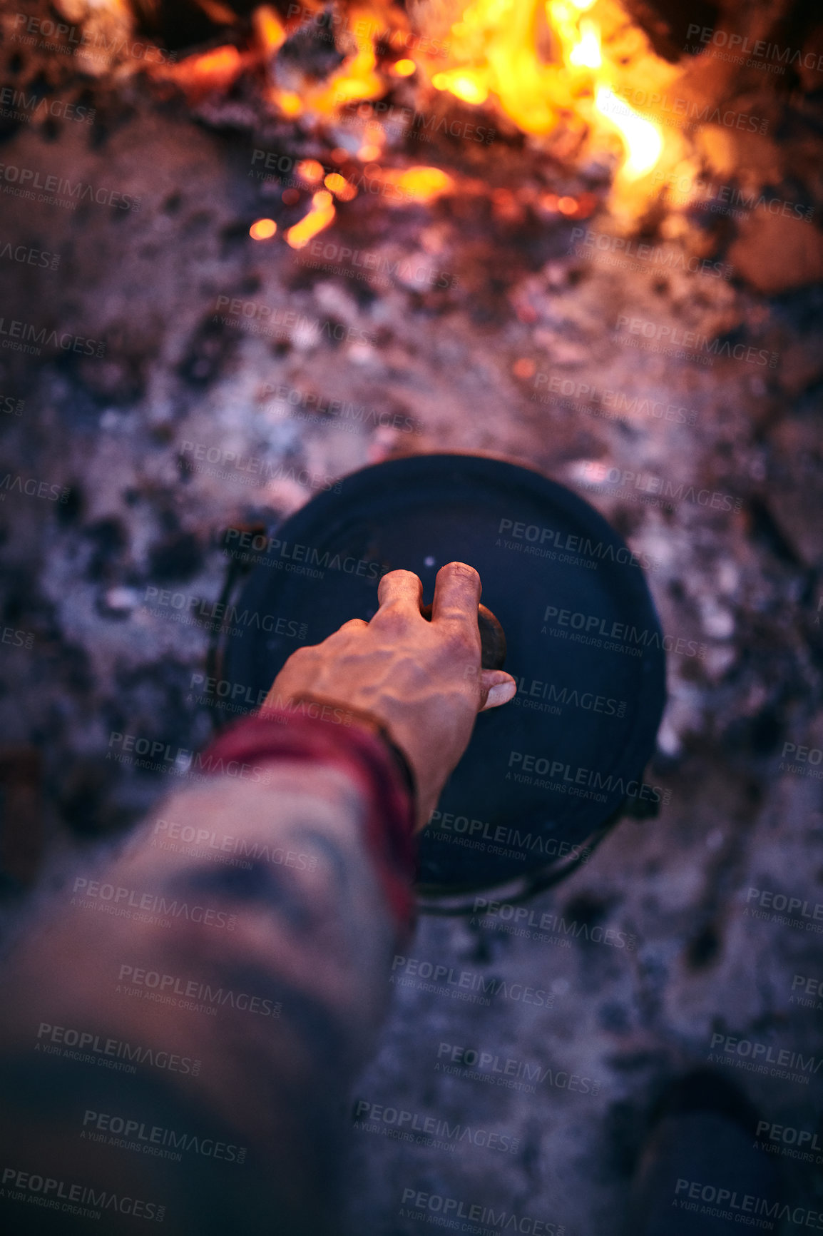 Buy stock photo Cropped shot of a man cooking traditional South African food by campfire outdoors