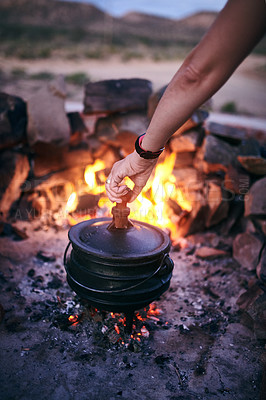Buy stock photo Cropped shot of a woman cooking traditional South African food by campfire outdoors