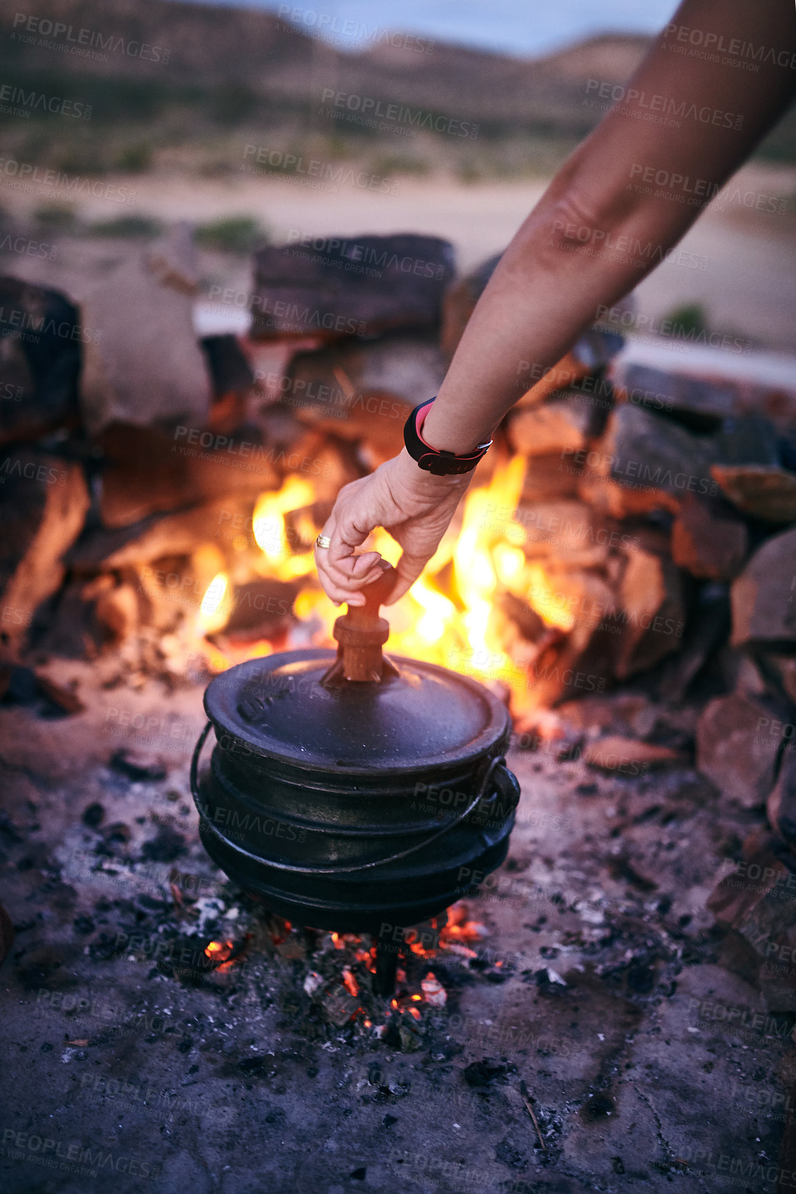 Buy stock photo Cropped shot of a woman cooking traditional South African food by campfire outdoors