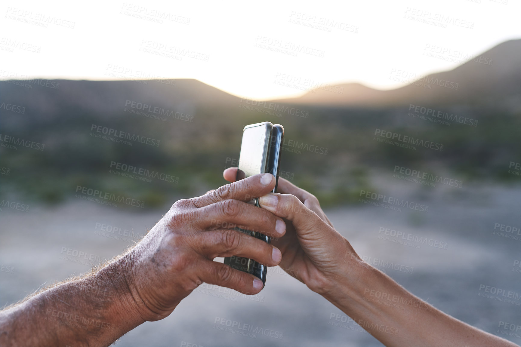 Buy stock photo Shot of an unrecognisable man and woman pairing their smartphones outdoors