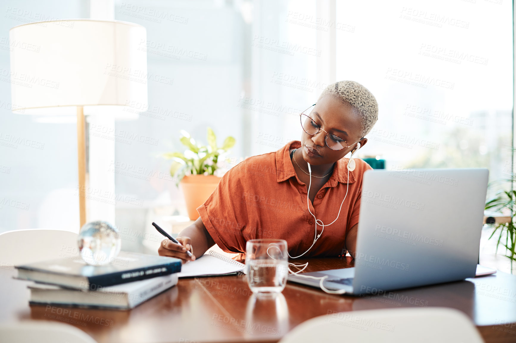 Buy stock photo African woman, earphones and writing in office with notebook, planning and inspiration at company. Person, thinking and laptop with ideas, solution and problem solving with music at creative agency