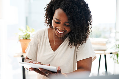 Buy stock photo Shot of a young businesswoman using a digital tablet in an office