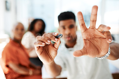 Buy stock photo POV shot of a young businessman holding a marker while giving a presentation in an office