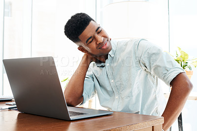 Buy stock photo Shot of a young businessman looking stressed while working at his desk in a modern office