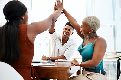Buy stock photo Shot of a group of businesspeople giving each other high five during a meeting in a modern office