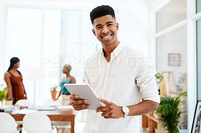 Buy stock photo Portrait of a young businessman using a digital tablet in a modern office