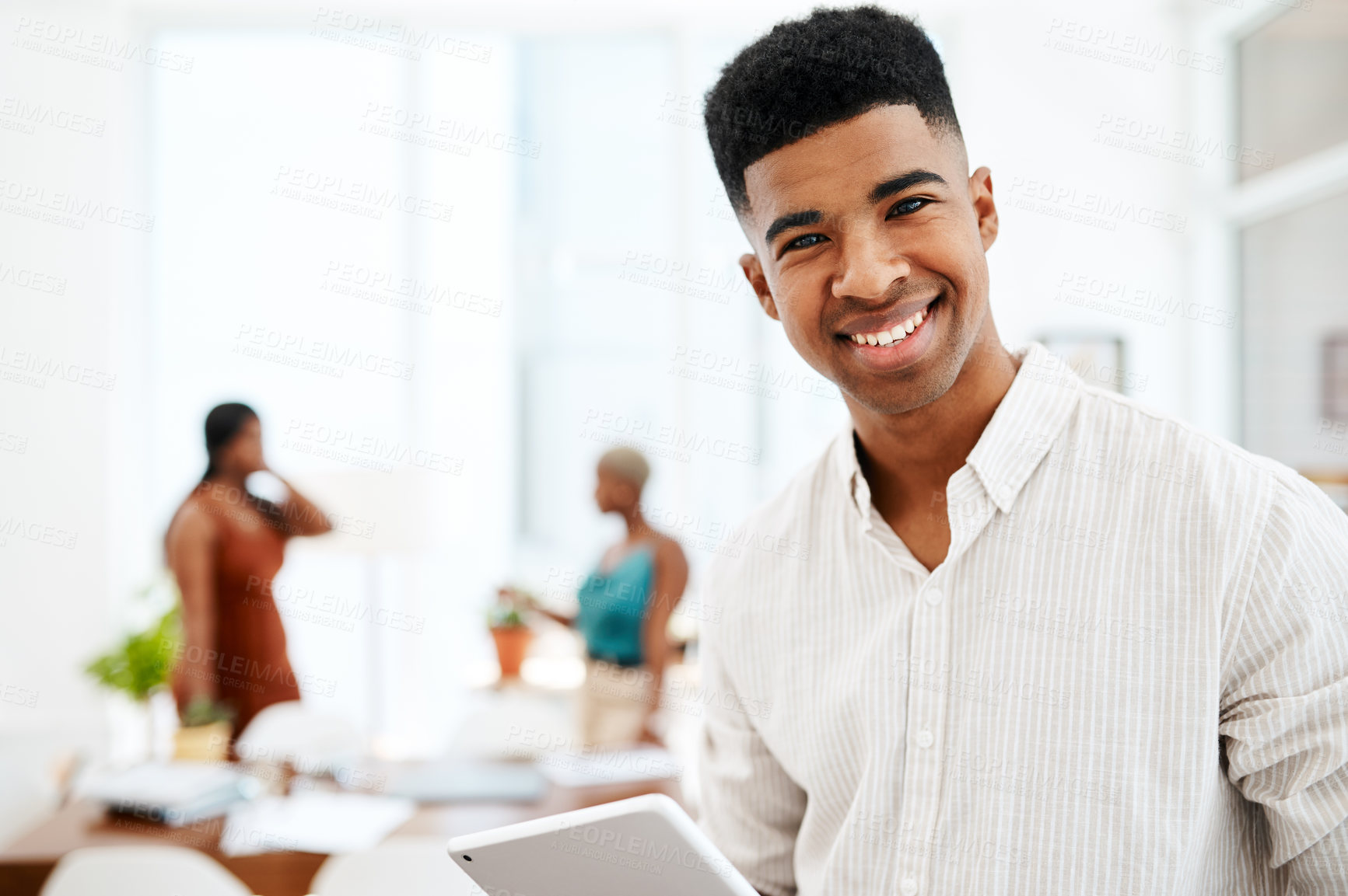 Buy stock photo Portrait of a young businessman using a digital tablet in a modern office