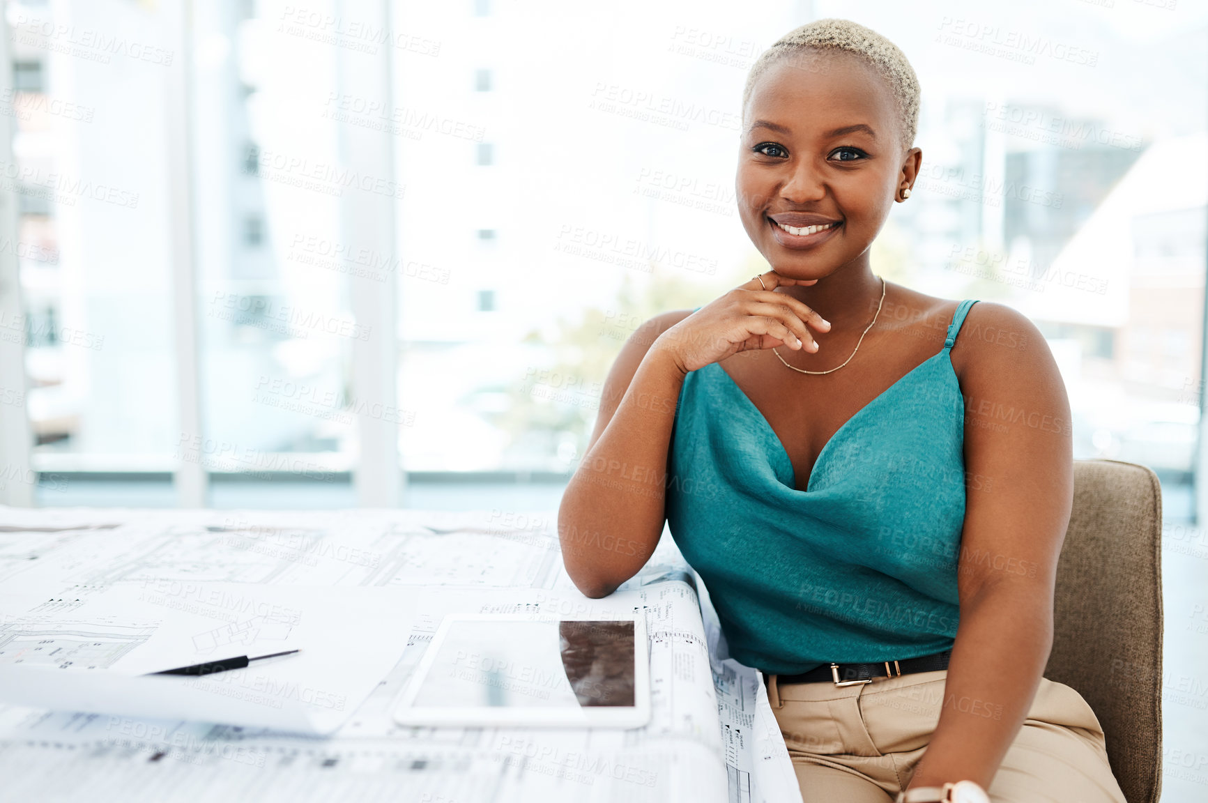 Buy stock photo Portrait of a young woman going over blueprints in a modern office
