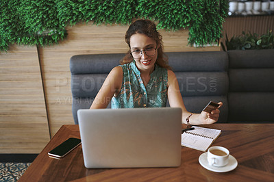 Buy stock photo Shot of a young woman using a laptop and credit card while working at a cafe