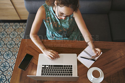 Buy stock photo High angle shot of a young woman using a laptop and credit card while working at a cafe