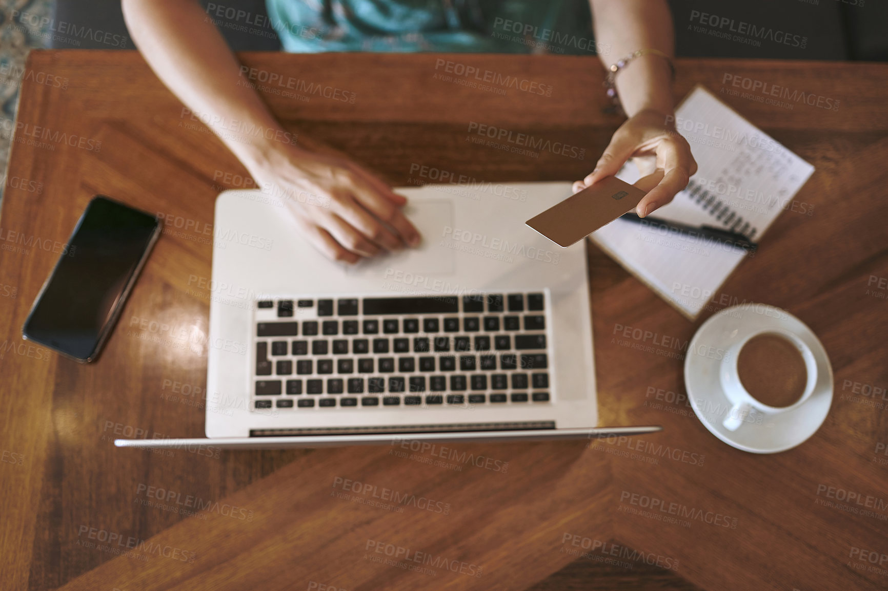 Buy stock photo High angle shot of a woman using a laptop and credit card while working at a cafe