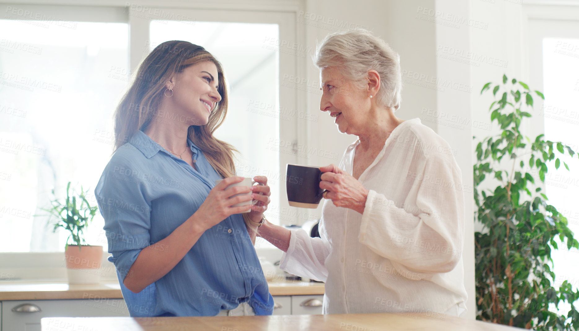 Buy stock photo Shot of a young woman and her senior mom spending quality time together at home