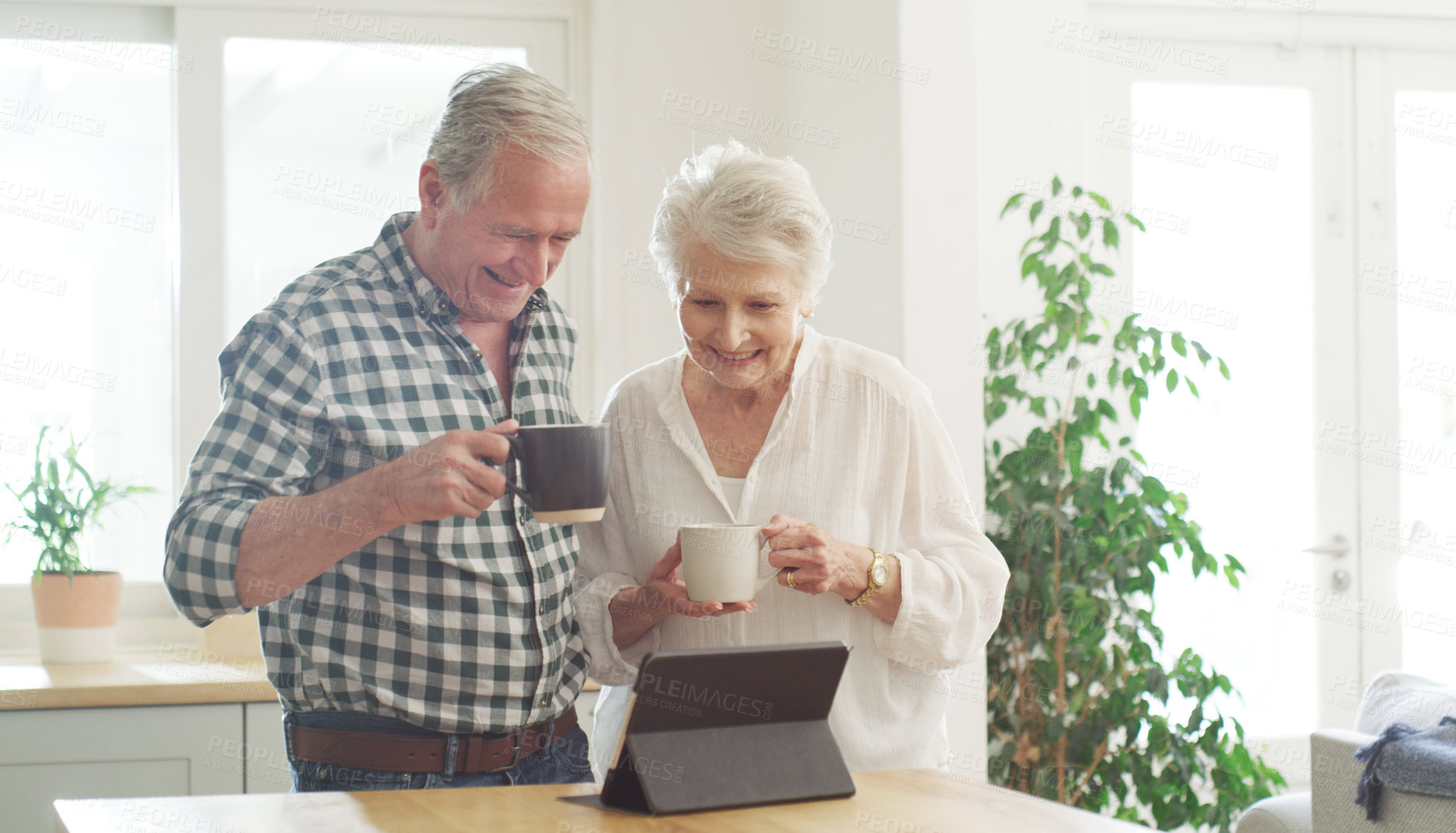 Buy stock photo Cropped shot of a senior couple looking at something on a digital tablet together