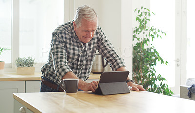 Buy stock photo Cropped shot of a senior man using a digital tablet at home