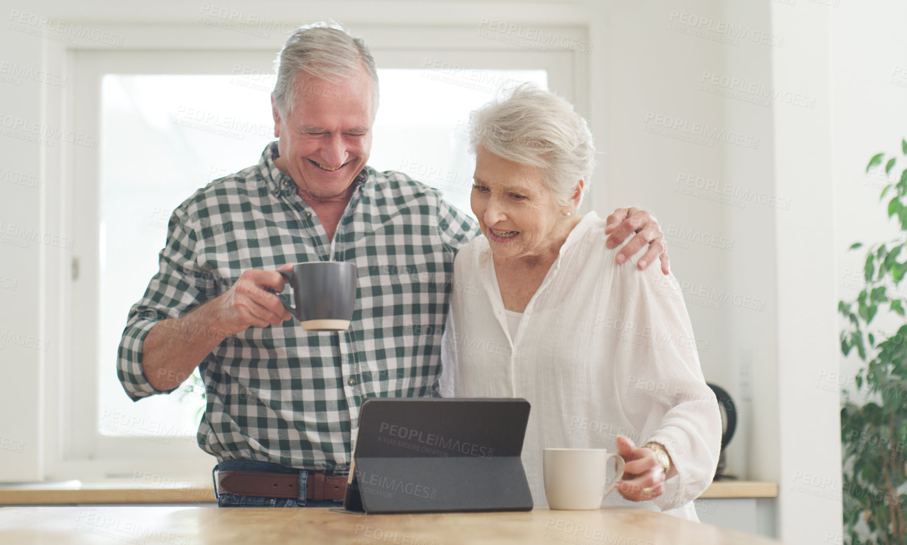 Buy stock photo Cropped shot of a senior couple looking at something on a digital tablet together