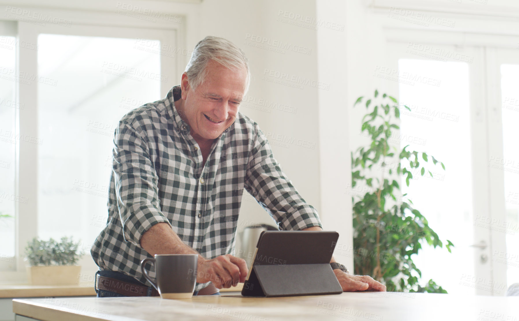 Buy stock photo Cropped shot of a senior man using a digital tablet at home