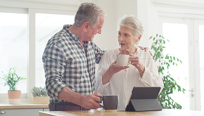 Buy stock photo Shot of a senior couple using a digital tablet at home